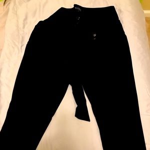 Black ankle length paper bag waist slacks.